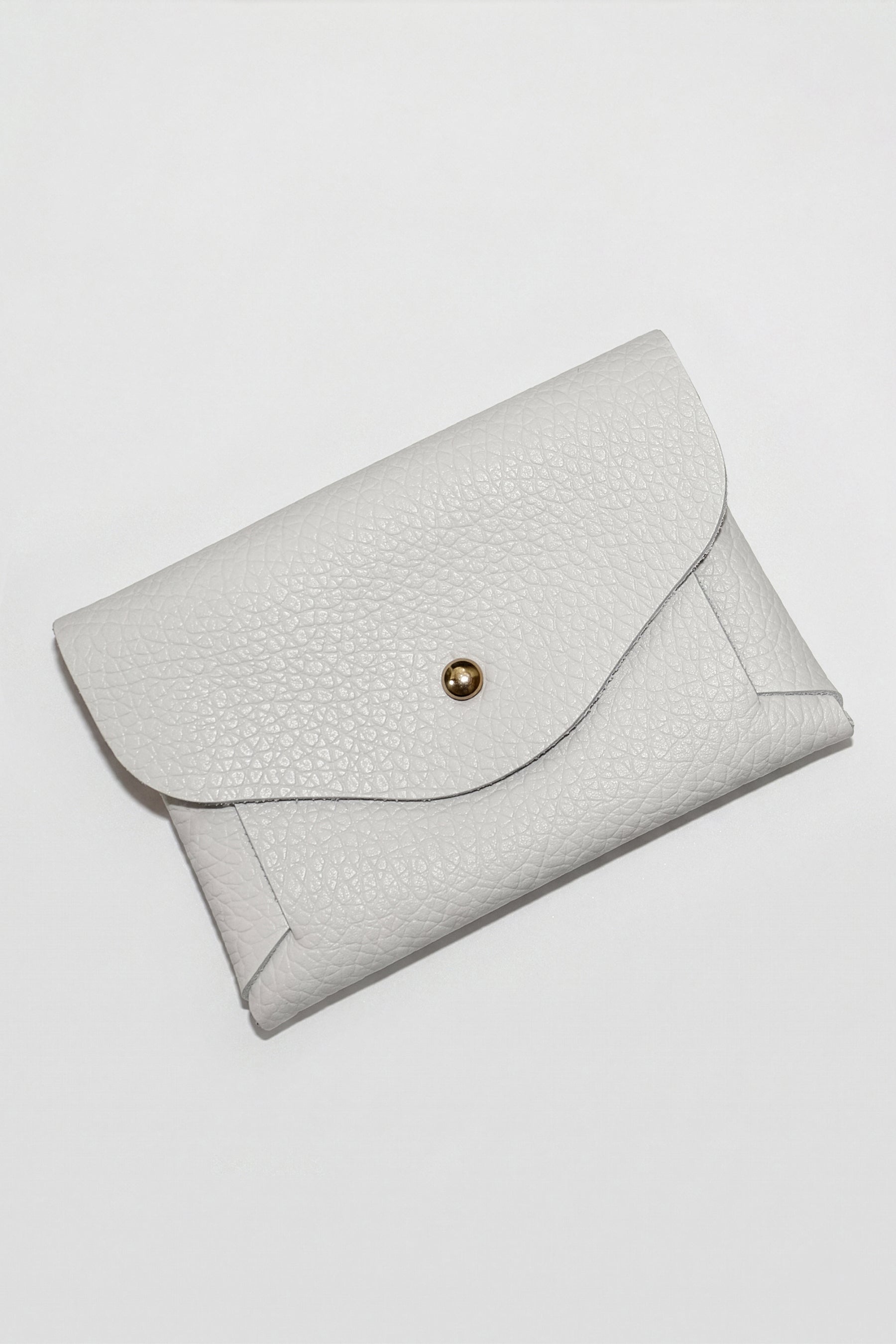 White textured leather pouch with curved flap closure and gold snap button.